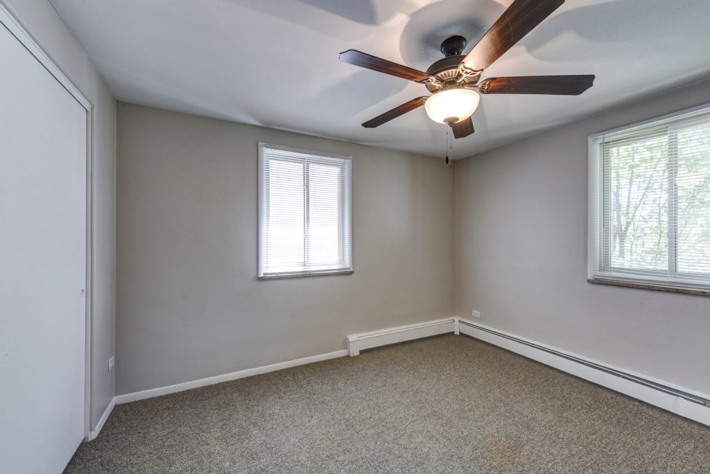 bedroom with two windows and ceiling fan